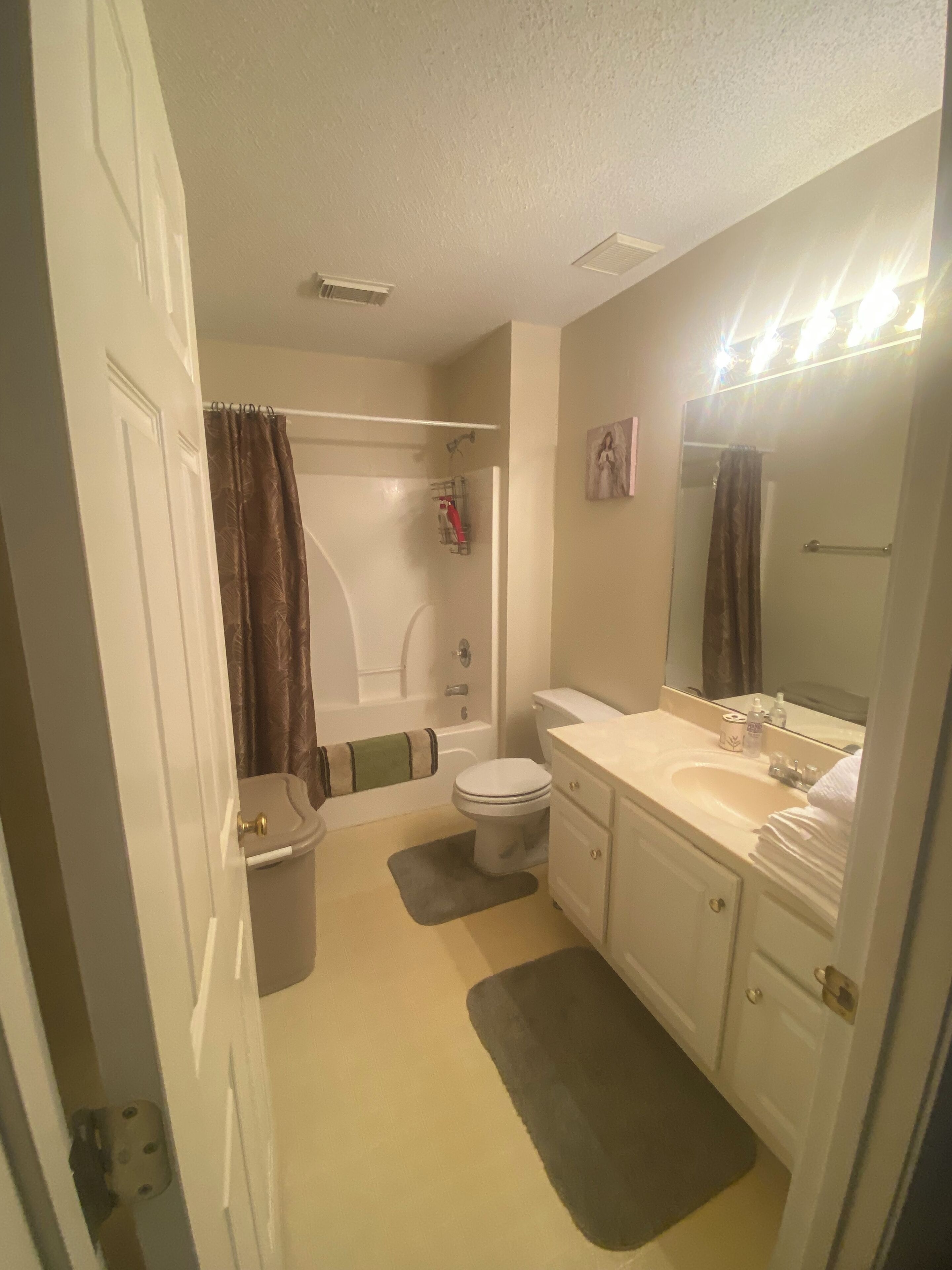 A bathroom with a bathtub, toilet, sink, and vanity.