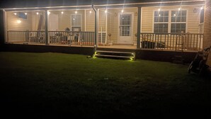 Una casa con porche cubierto y un pequeño jardín delantero.