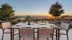 A table set for four with wine glasses and plates, overlooking a scenic landscape with trees and hills. - Cottage Retreat at Paradise Ridge by Kohmsa (Santa Rosa)