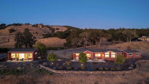 A modern two-story house with a patio and a stone wall surrounding the property. - Paradise Ridge Vineyard Retreat - Hot Tub & Views (Santa Rosa)