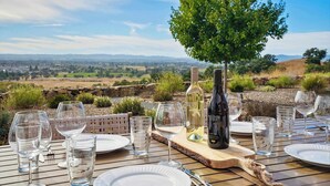 A table set for dining with wine bottles and glasses, overlooking a scenic landscape. - Paradise Ridge Vineyard Retreat - Hot Tub & Views (Santa Rosa)