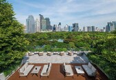 A rooftop terrace with outdoor seating and a city skyline view.