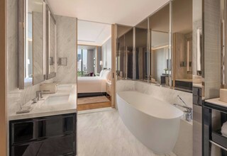 A modern bathroom with a large bathtub, a vanity with a mirror, and a separate shower area.