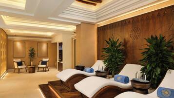 Relax in a serene spa room with a wooden reception desk, lounge chairs, and a potted plant.
