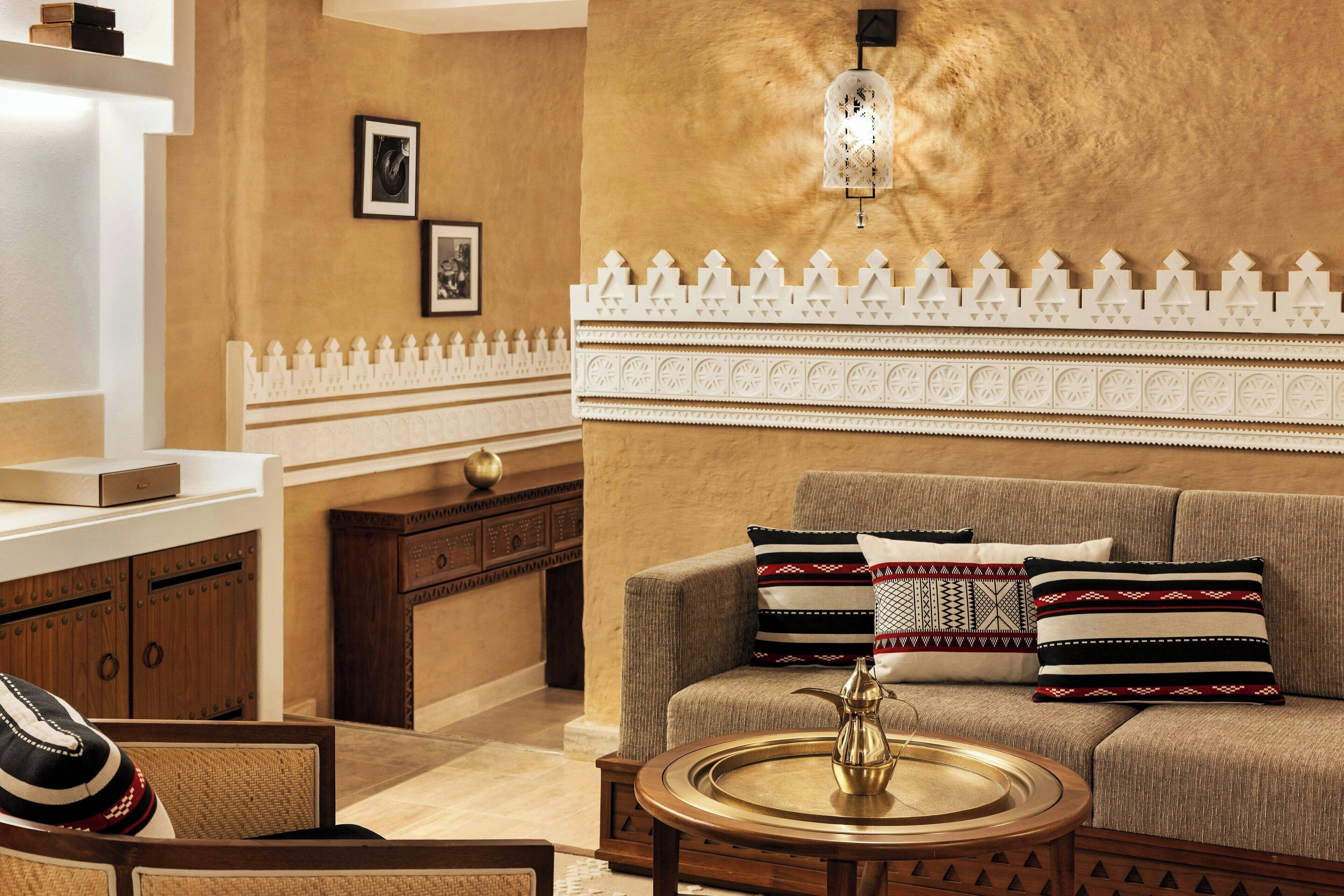 A cozy living area with a sofa, a coffee table, and a decorative wall with a patterned border.