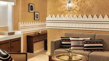 A cozy living area with a sofa, a coffee table, and a decorative wall with a patterned border.