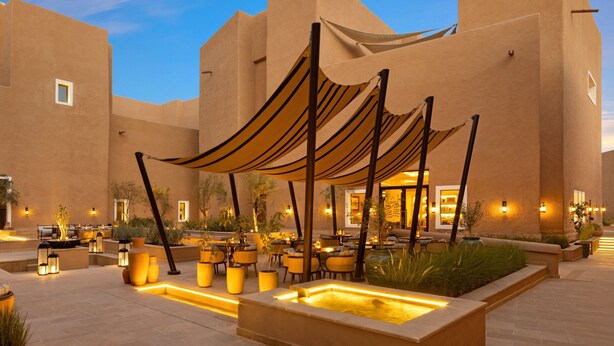 An outdoor patio area with seating, a water feature, and a building facade. - Bab Samhan, A Luxury Collection Hotel, Diriyah (Diryah)