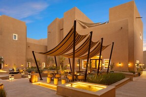 An outdoor patio area with seating, a water feature, and a building facade. - Bab Samhan, A Luxury Collection Hotel, Diriyah (Diryah)