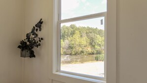A room with a window overlooking a river and forest. - The Florio, Tiny Home, River, Hiking, and Rafting! (Sylva)