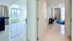 A modern hotel room with a large window, a desk, and a blue rug. - Panoramic Burj Khalifa View Luxury Penthouse 1BR (Dubai)