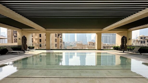 A rooftop swimming pool with a view of the city skyline. - Stunning Burj View Sky High Luxury 2BR (Dubai)