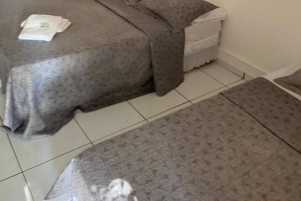 A room with a bed, a small table, and a bench.