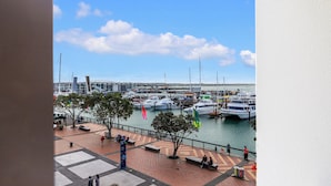 A marina with boats docked, a pedestrian walkway, and a view of the water. - Viaduct Harbour Views w/ Free Parking-Zodiak Stays (Auckland)