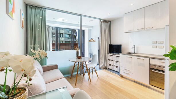A modern apartment with a living room, dining area, and kitchen. - Sleek central stay with balcony by Zodiak Stays (Auckland)