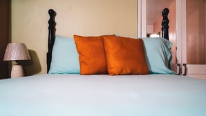 Ein Bett mit Holz Kopfteil, zwei Kissen und einer Nachttischlampe.