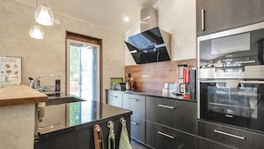 Una cocina moderna con una isla central, electrodomésticos integrados y un amplio ventanal.