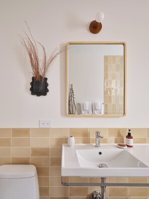 Ein Badezimmer mit Waschbecken, Spiegel und Toilette.