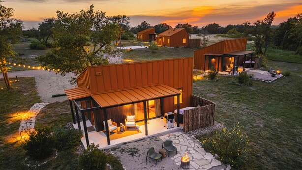 A modern outdoor living area with a fire pit, seating, and a covered patio. - The Martinsburg (Stonewall)