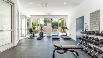Stay active with our fully equipped fitness center featuring treadmills, a bench press, dumbbells, and a rowing machine.