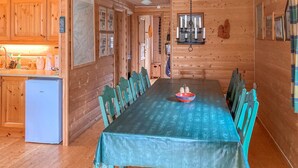 A wooden cabin with a dining table, chairs, a refrigerator, and a kitchen area. - Gorgeous home in Dirdal (Dirdal)