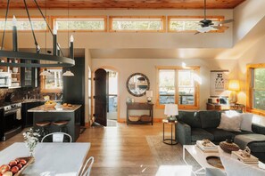 Un grand espace de vie comprenant une cuisine, une table à manger et un coin salon confortable.