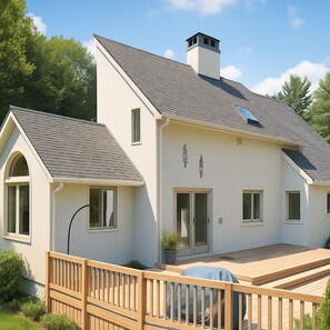 A modern house with a sloped roof, a chimney, and a deck with a wooden railing. - Sunny Peace Homestay (Harwinton)