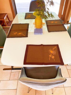 A dining table with a vase of flowers, placemats, and a chair. - Sunny Peace Homestay (Harwinton)