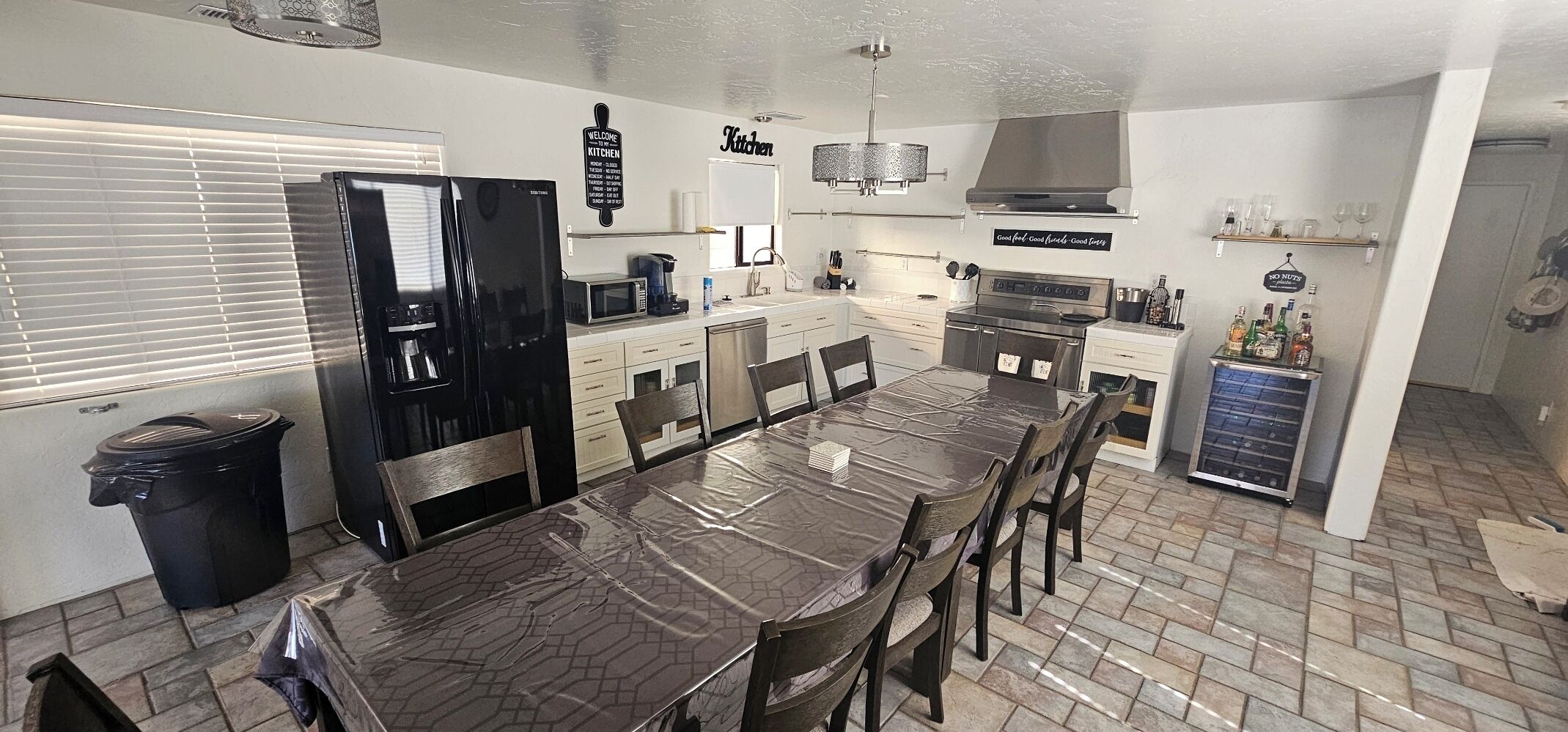 A modern kitchen with a large island, stainless steel appliances, and a dining area with a table and chairs.