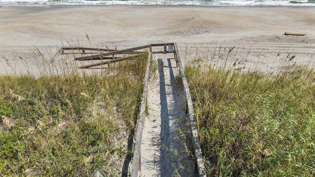 A beach path leading to the ocean with a wooden fence and a sign. - Carolina Breeze by Carolina Getaway - Spacious 3BR Condo w/ Ocean & Sound Views (Carolina Beach)