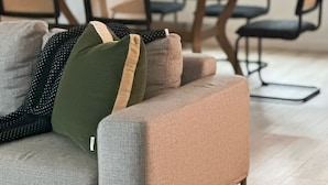 Un salon moderne avec un canapé, une table à manger, des chaises et une plante en pot.