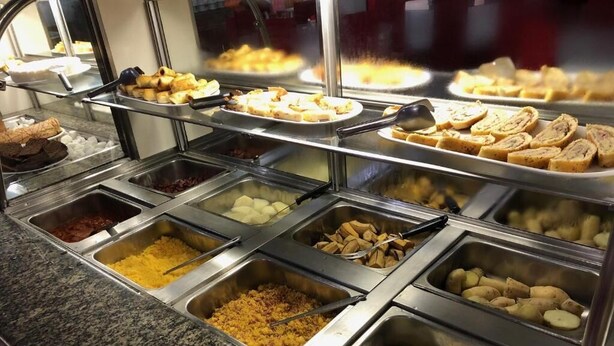 En buffet med forskellig mad i metalbeholdere.