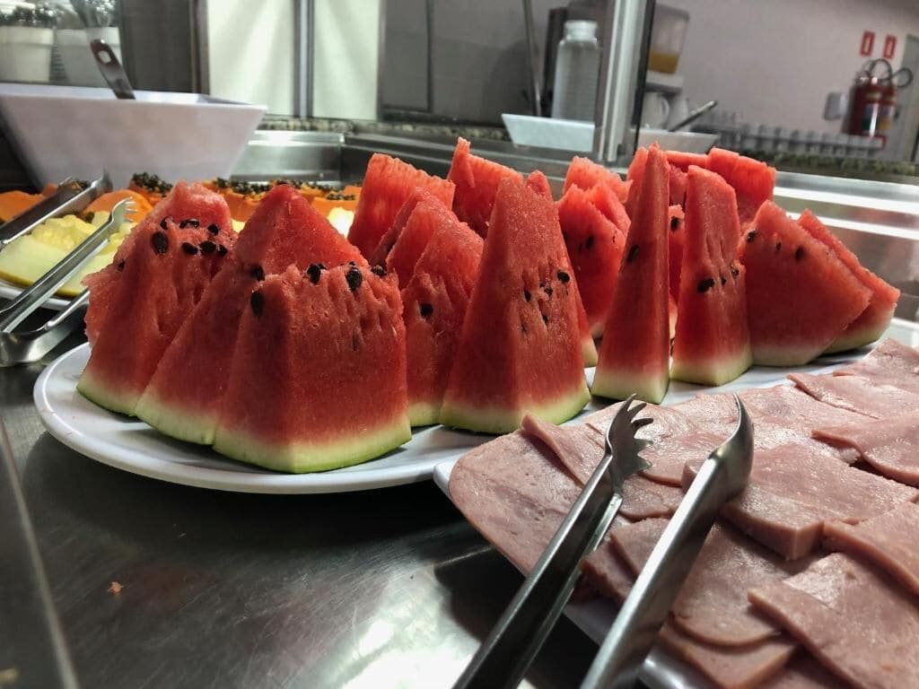 Un plat de trossos de síndria sobre una taula de buffet.