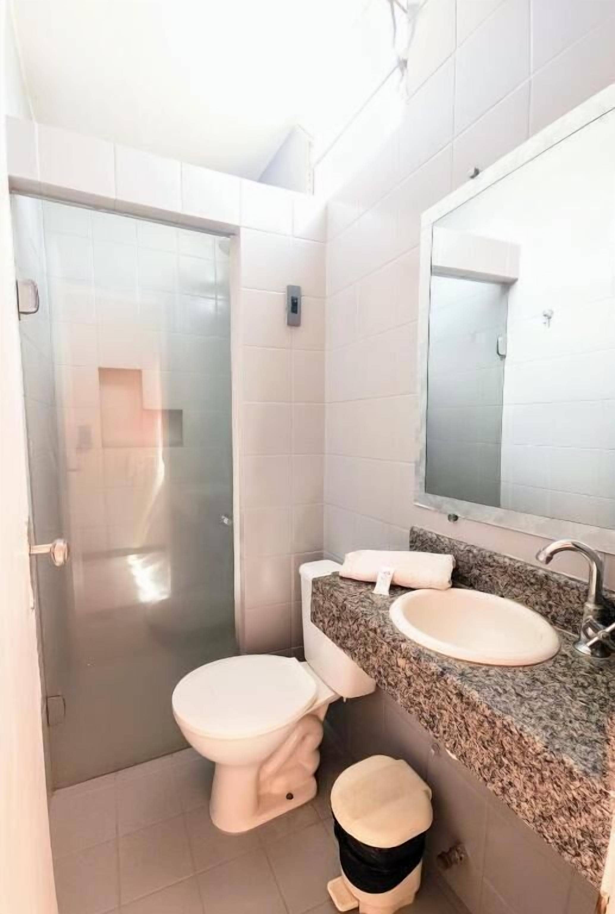 A bathroom with a toilet, sink, and shower.