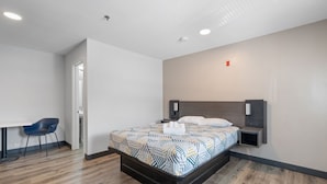 Een moderne hotelkamer met een groot bed, een bureau en een stoel.
