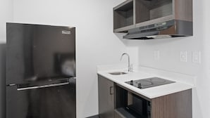 Een moderne keuken met een roestvrijstalen koelkast, een dubbele spoelbak en een inbouwoven.
