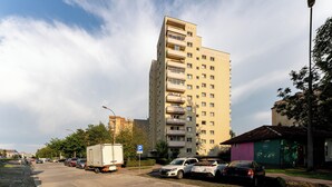 A multi-story building with a parking lot in front.