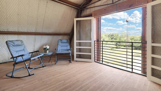 Un balcone con vista su vegetazione e cielo sereno.