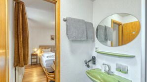 A hotel room with a bed, bedside table, lamp, and a view of another room. - Beautiful apartment in Bischofsheim (Bischofsheim)