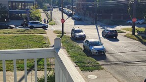 A street view with cars, a stop sign, and buildings. - Timeless Tremont- Enjoy 20% off 5+ nights  (Cleveland)