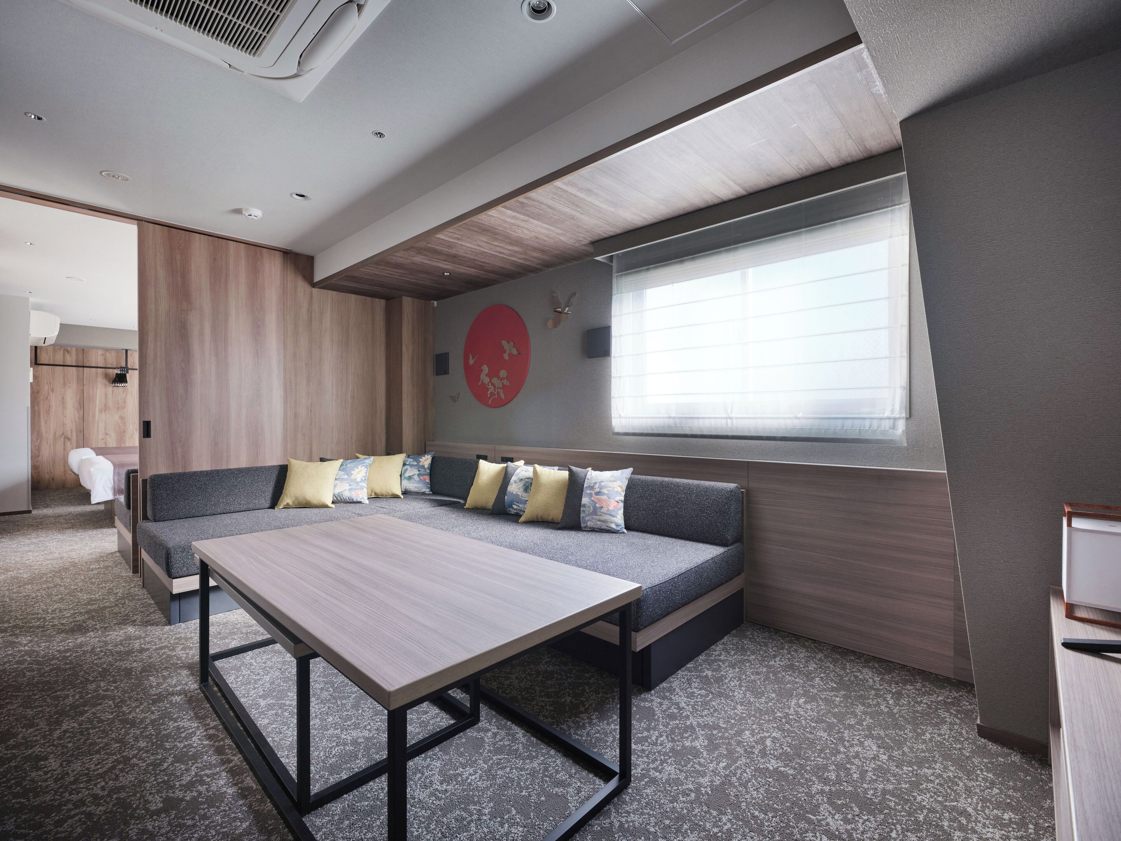 A modern room with a sofa, a table, and a window.