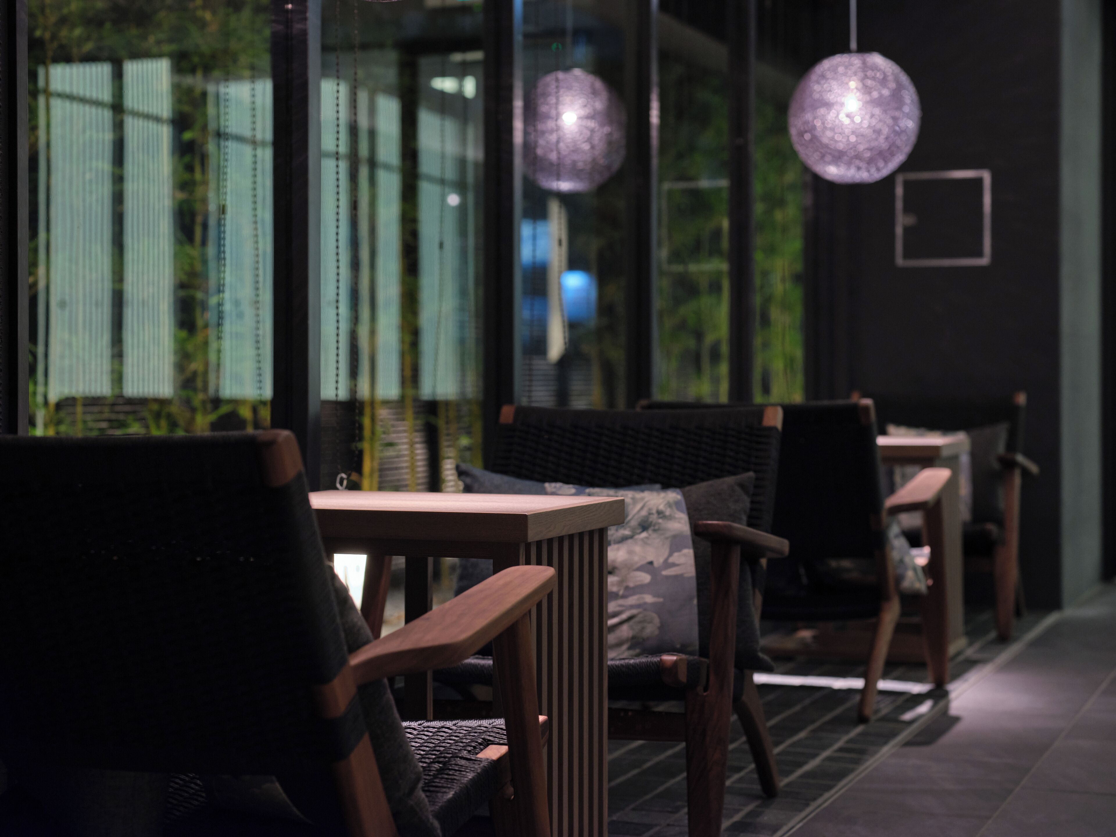 A modern interior with wooden furniture and hanging spherical lights.