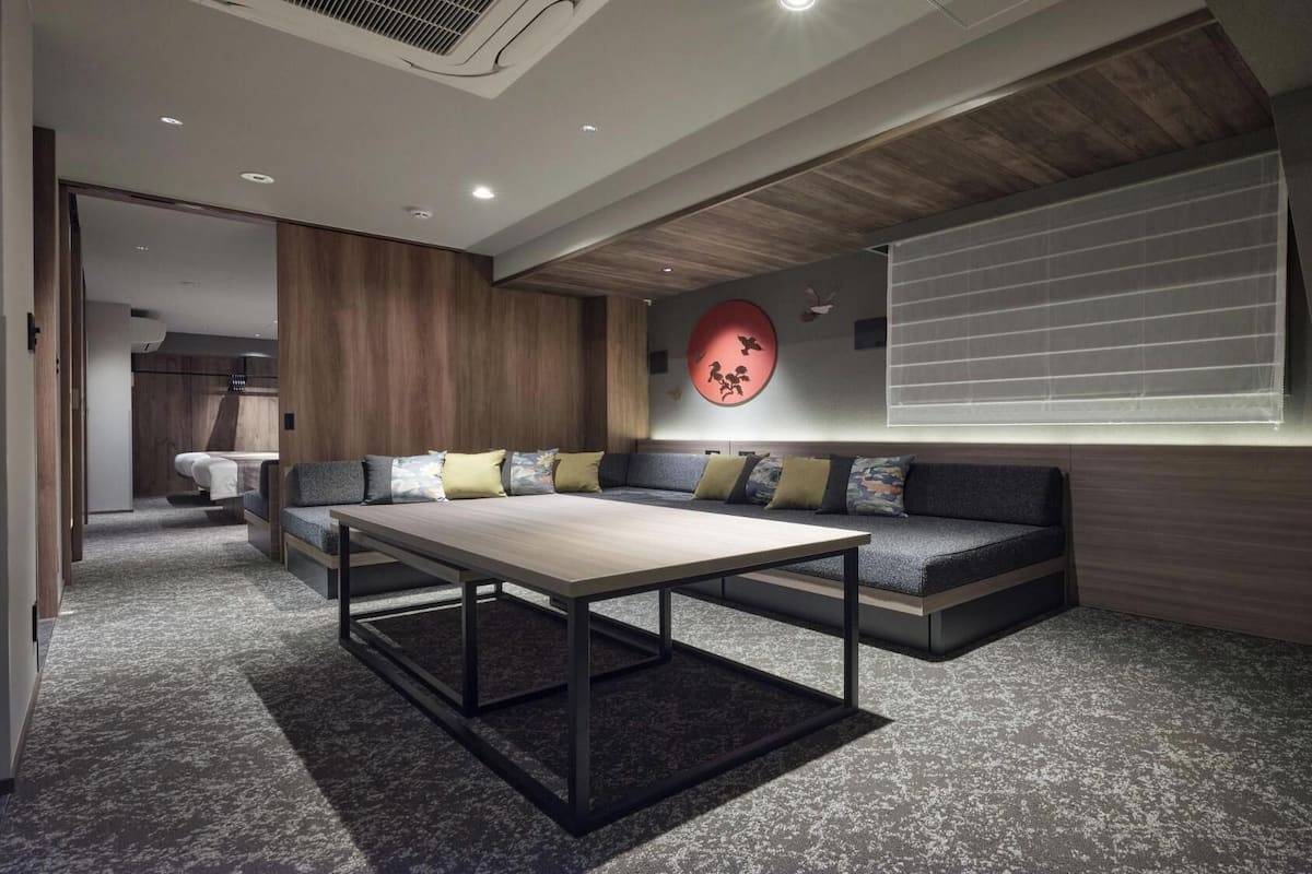 A modern interior with a sofa, a table, and a decorative wall piece.