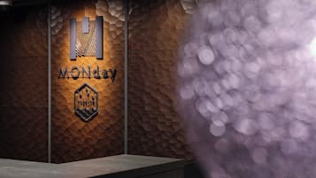 A reception desk with a wooden textured wall and a logo that reads "MONDAY".