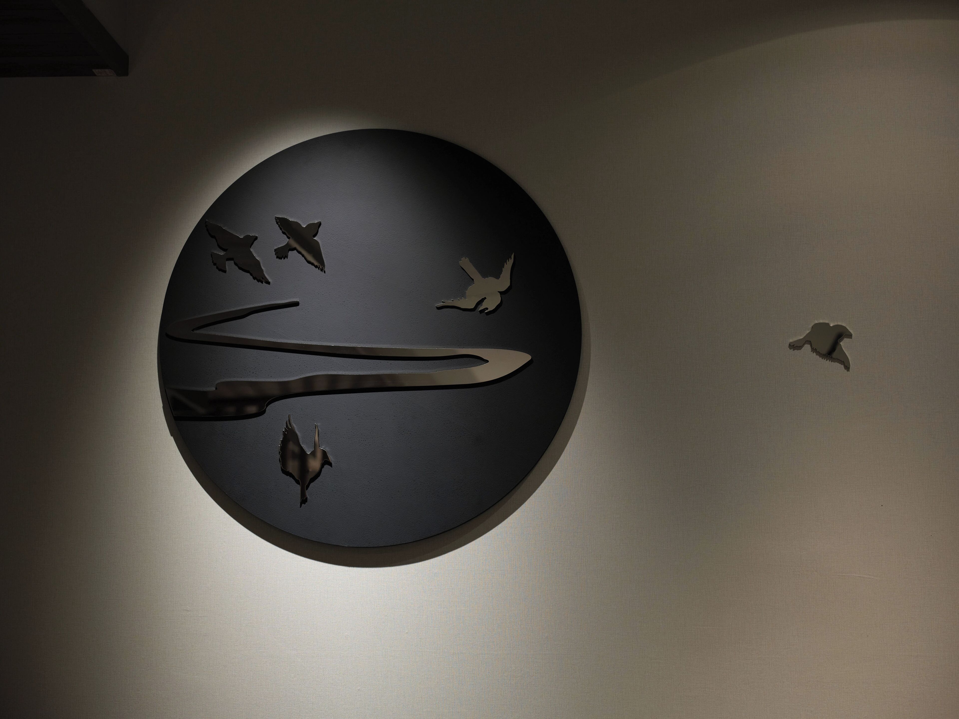 A circular wall art with bird silhouettes.