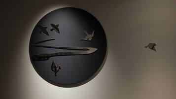 A circular wall art with bird silhouettes.