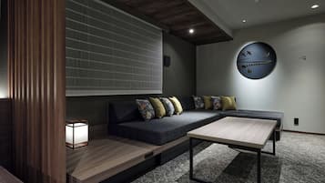 Una sala moderna con un sofá seccional, una mesa de centro y un reloj de pared.