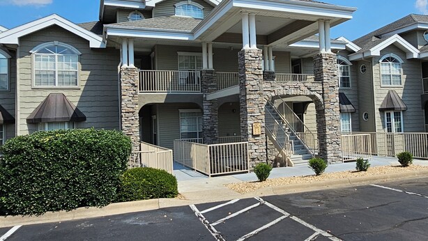 A multi-story residential building with a stone facade, balconies, and a covered entrance. - 3-Bedroom Condo, Penthouse Suite, Remodeled, Golf Course View, Excellent Rates!! (Branson)