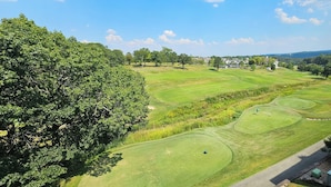 A golf course with a view of a large tree, a golf cart, and a building in the background. - 3-Bedroom Condo, Penthouse Suite, Remodeled, Golf Course View, Excellent Rates!! (Branson)