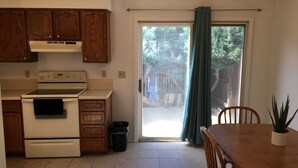 A kitchen with wooden cabinets, a stove, and a dining table with chairs. - 1,800sf 3 Stories with 8 beds townhome (Casper)