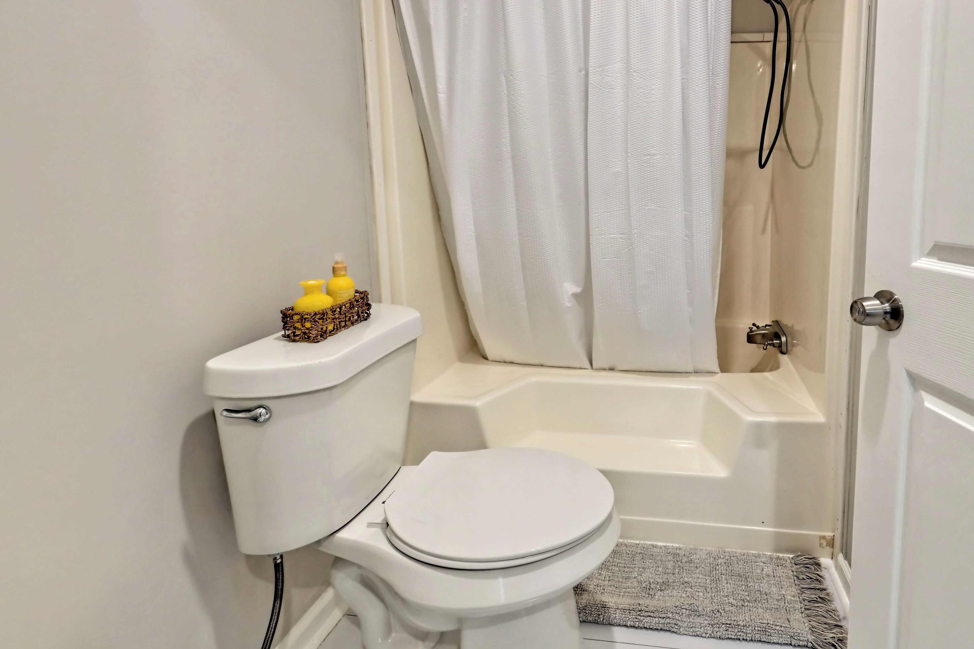 Un baño con inodoro, bañera y cortina de ducha.